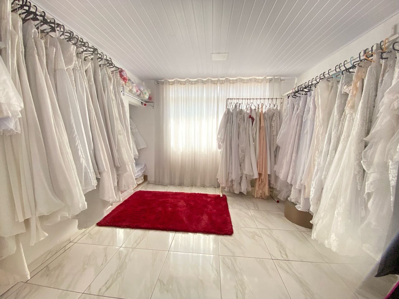 Sala de provas com vestidos claros