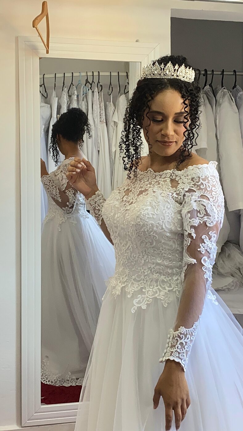 Noiva na prova do vestido diante do espelho