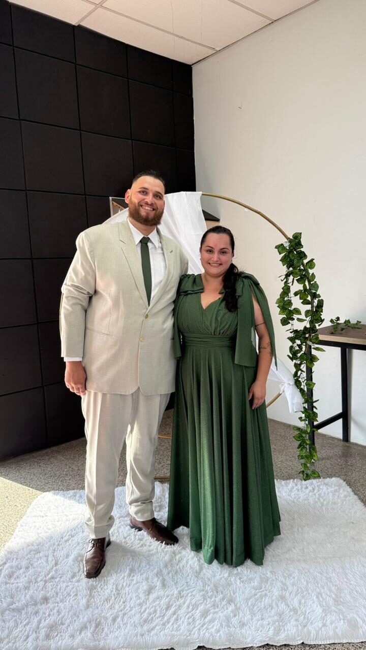 Casal com terno claro e vestido verde